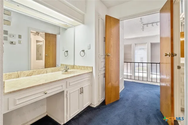 a view of a hallway and a kitchen with windows