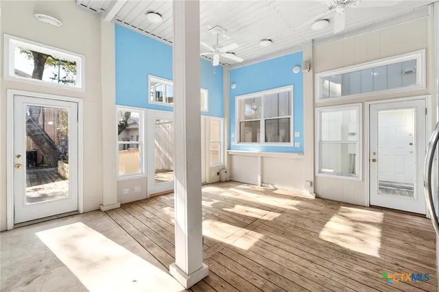 a view of a kitchen with refrigerator and wooden floor