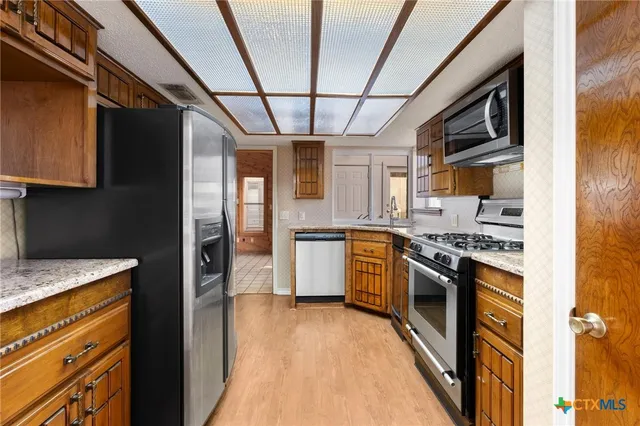 a kitchen with stainless steel appliances granite countertop a stove and a refrigerator