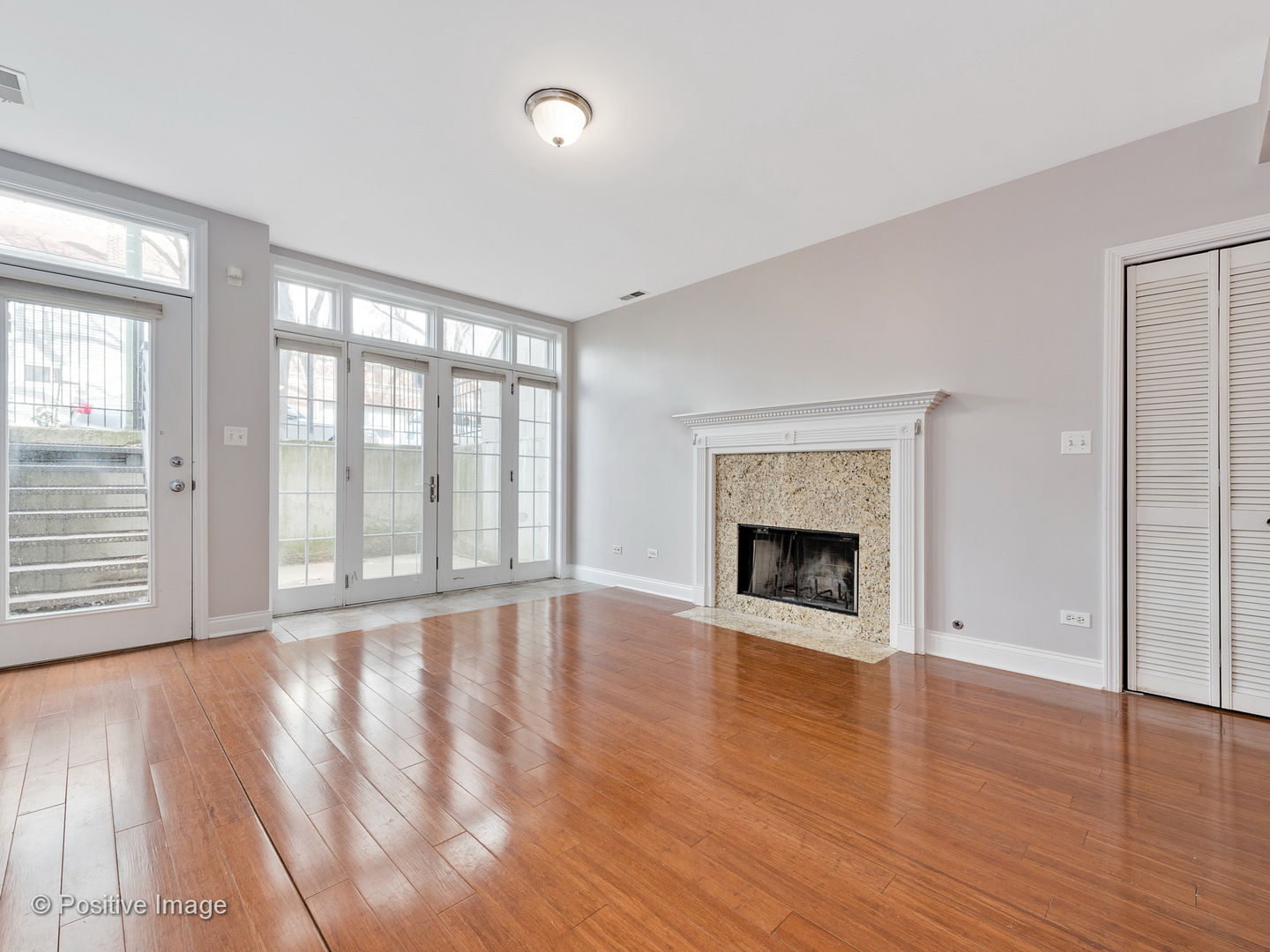 526 North May Street, Unit 1 Chicago, IL 60642 - Photo 3 of 15 wooden floor fireplace and windows in an empty room