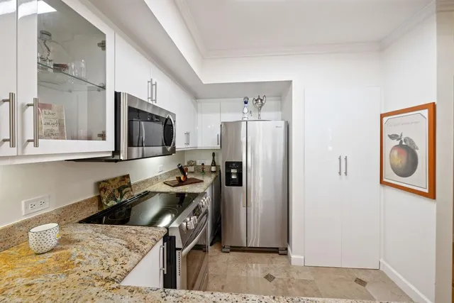 a kitchen with stainless steel appliances granite countertop a refrigerator a stove top oven a sink and dishwasher