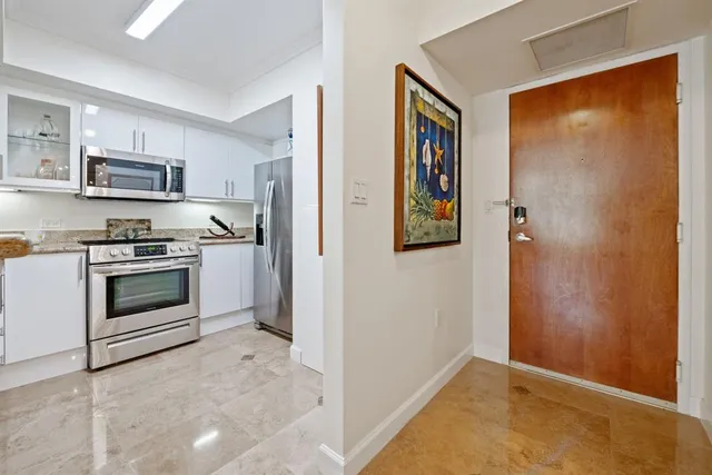 a view of a kitchen with stainless steel appliances granite countertop a stove and a refrigerator