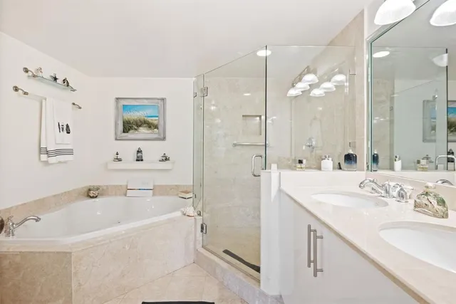 a bathroom with a tub sink and mirror