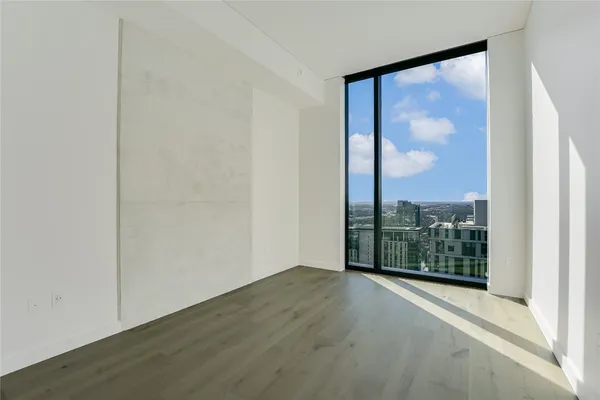 a view of a room with wooden floor and a window