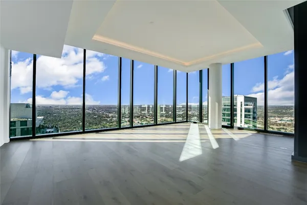 a view of room with balcony and wooden floor