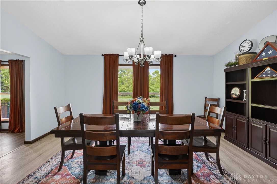 2165 Stewart Road Xenia, OH 45385 - Photo 7 of 59 This bright dining room features warm wood flooring and a chandelier.