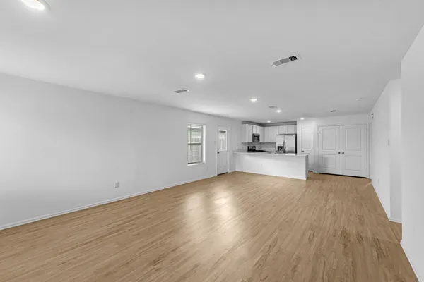 a view of empty room with wooden floor