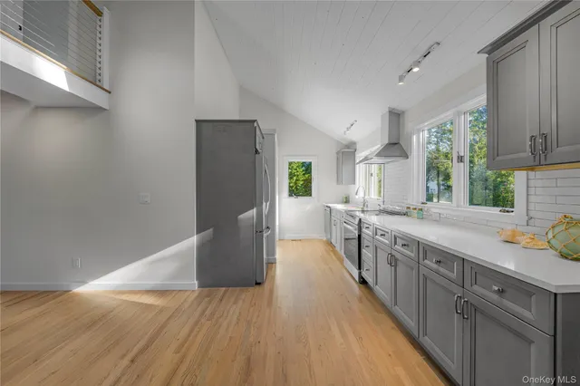 a kitchen with stainless steel appliances kitchen island granite countertop a stove a sink and a refrigerator