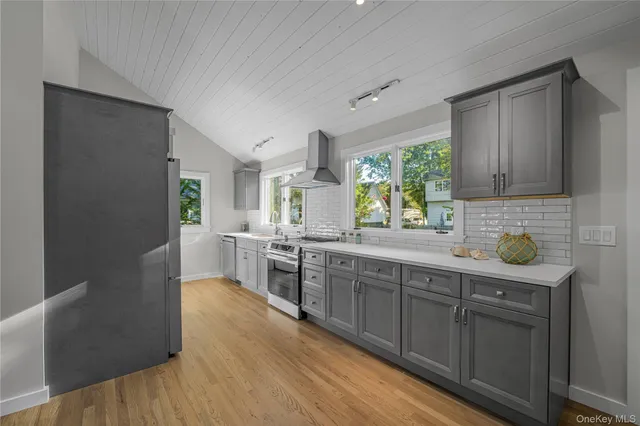 a kitchen with kitchen island a sink appliances and cabinets