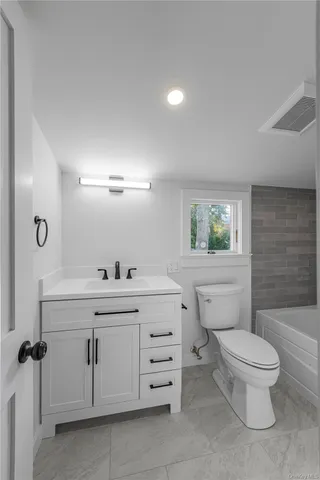 an empty room with a window and a ceiling fan