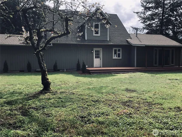 a house that has a tree in front of a house