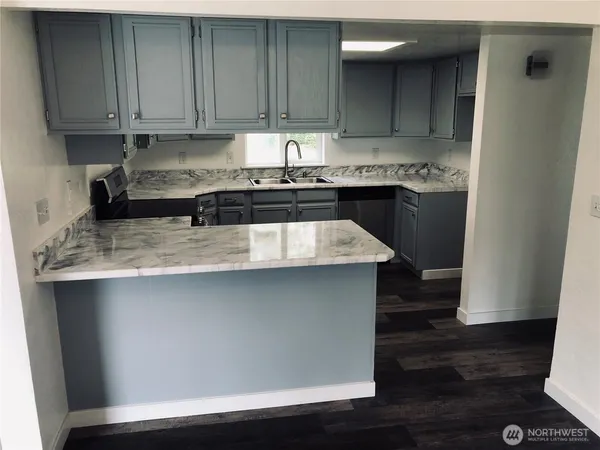 a kitchen with granite countertop a sink and a stove