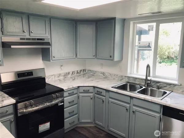 a kitchen with granite countertop a sink and a stove