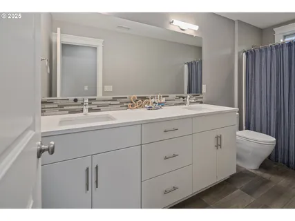 a bathroom with a double vanity sink mirror and toilet