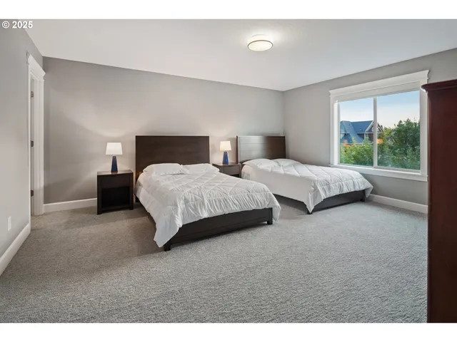 a bedroom with two beds and windows