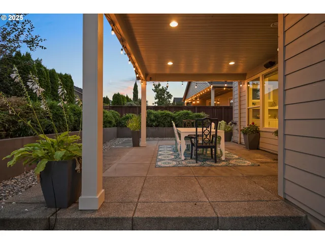 a view of a patio with a table and chairs and potted plants
