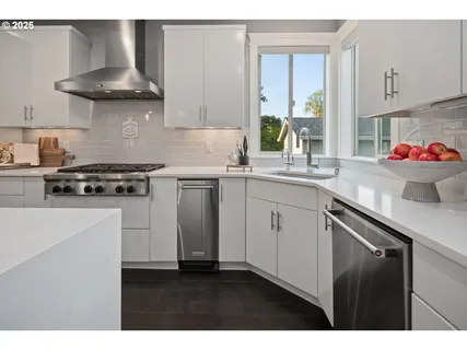 a kitchen with a sink a stove and cabinets