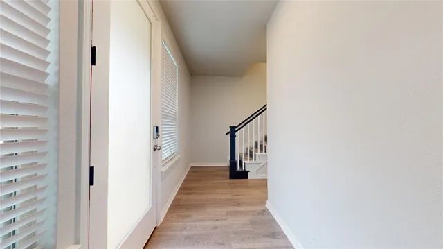 a view of a hallway with wooden floor and staircase