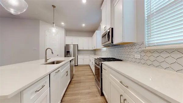 a kitchen with sink a stove and oven