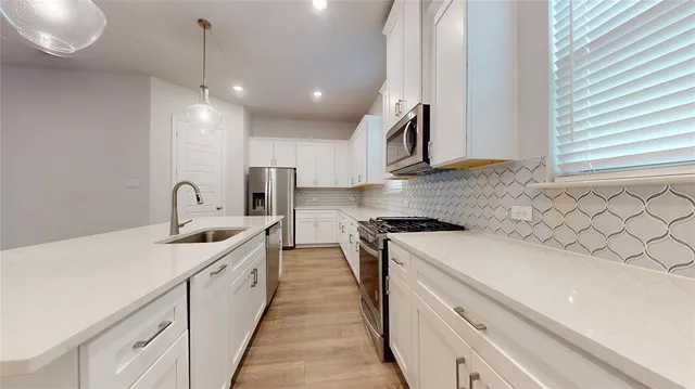 a kitchen with sink a stove and oven