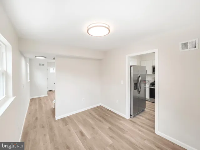 a view of a hallway with wooden floor and a bathroom