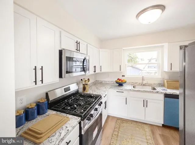 a kitchen with stainless steel appliances a sink stove and cabinets