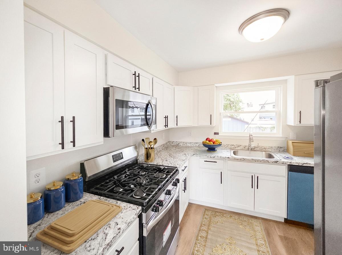 6516 Columbia Park Road Landover, MD 20785 - Photo 7 of 25 a kitchen with stainless steel appliances a sink stove and cabinets
