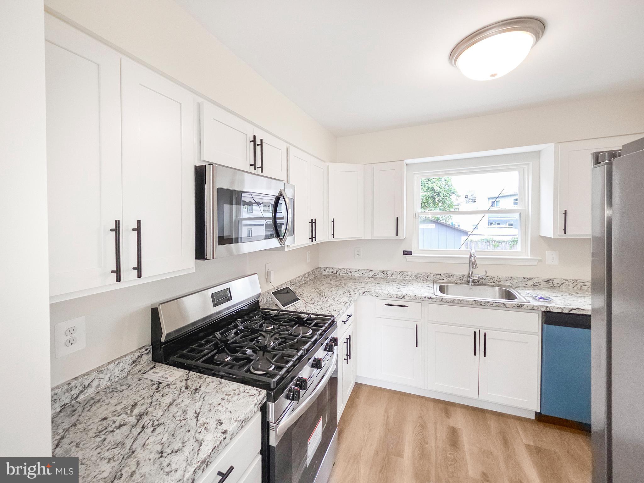 6516 Columbia Park Road Landover, MD 20785 - Photo 8 of 25 a kitchen with a stove a sink and a microwave