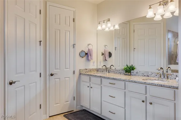 a bathroom with double vanity and a mirror