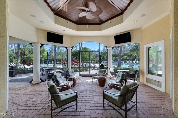 a living room with patio fireplace furniture and a large window
