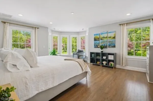 a bed sitting in a spacious bedroom next to a window