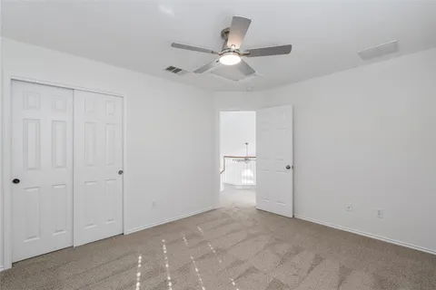 an empty room with a window and a fan