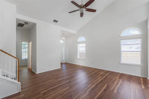 a view of a big room with wooden floor and windows