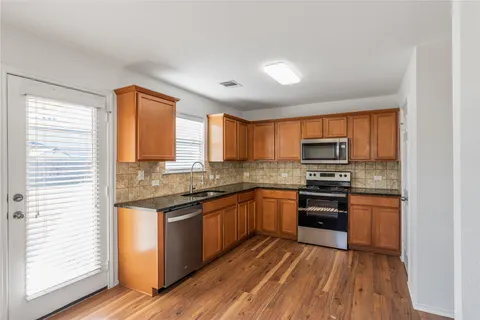 a kitchen with stainless steel appliances granite countertop a stove a sink and a refrigerator