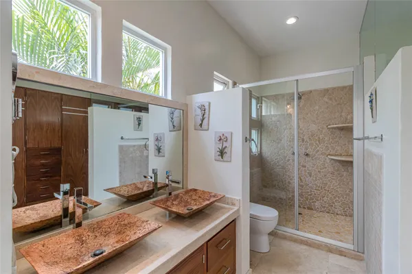 a bathroom with a granite countertop sink toilet and shower
