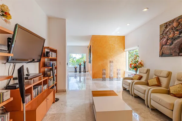 a bedroom with a bed a large window and a flat tv screen on dresser