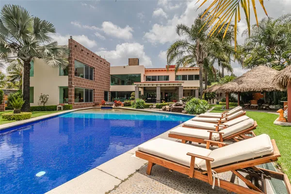 a swimming pool with outdoor seating and yard
