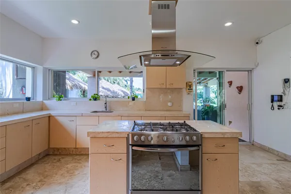 a kitchen with kitchen island granite countertop a refrigerator and a sink