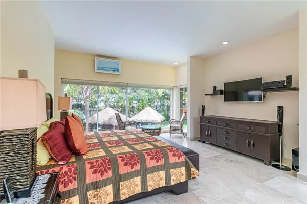 a bedroom with a bed and large windows