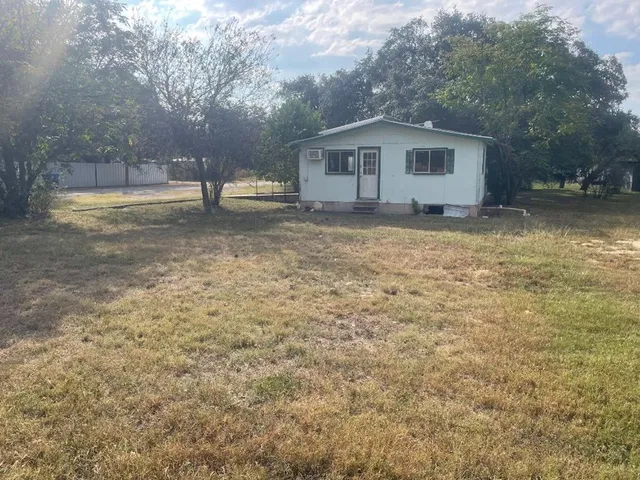 a front view of house with yard and trees