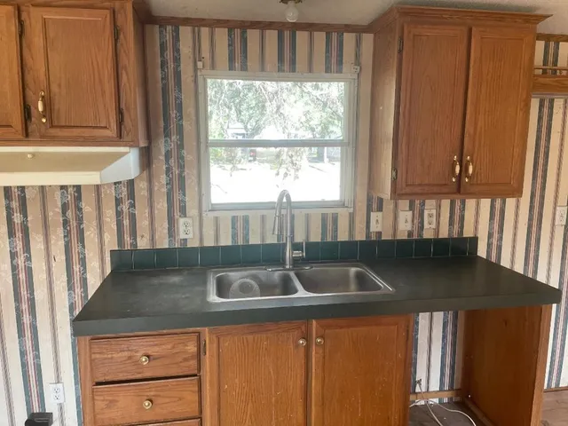 a kitchen with granite countertop a sink and a window