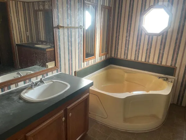 a bath tub sitting in a bathroom next to a sink