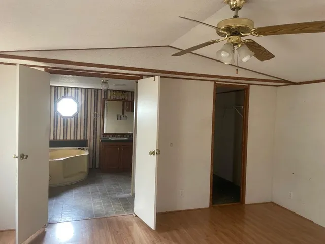 a view of a hallway with wooden floor and a cabinet