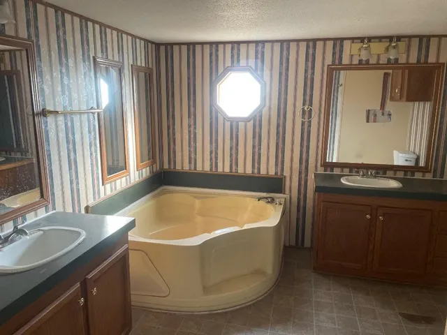 a bathroom with a tub sink and mirror