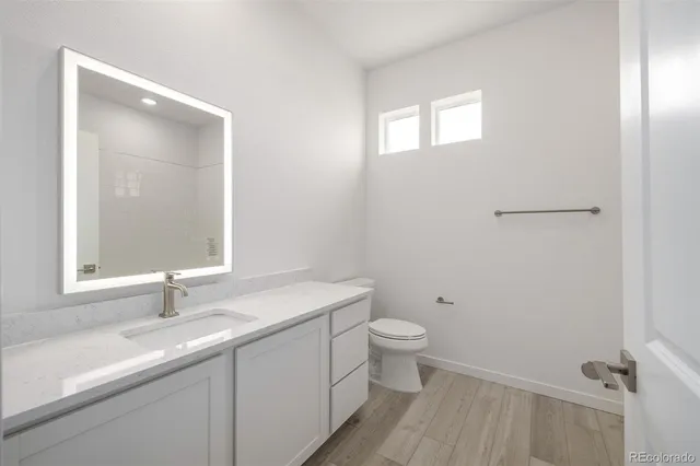 a bathroom with a sink a toilet and a mirror