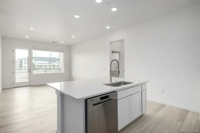 a kitchen with a sink cabinets and wooden floor
