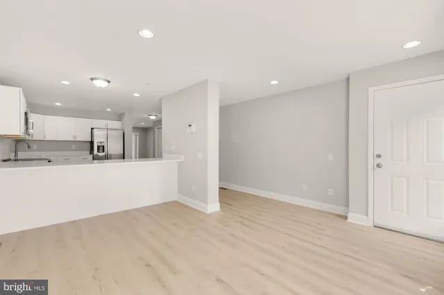 a view of kitchen with kitchen island white cabinets and wooden floor