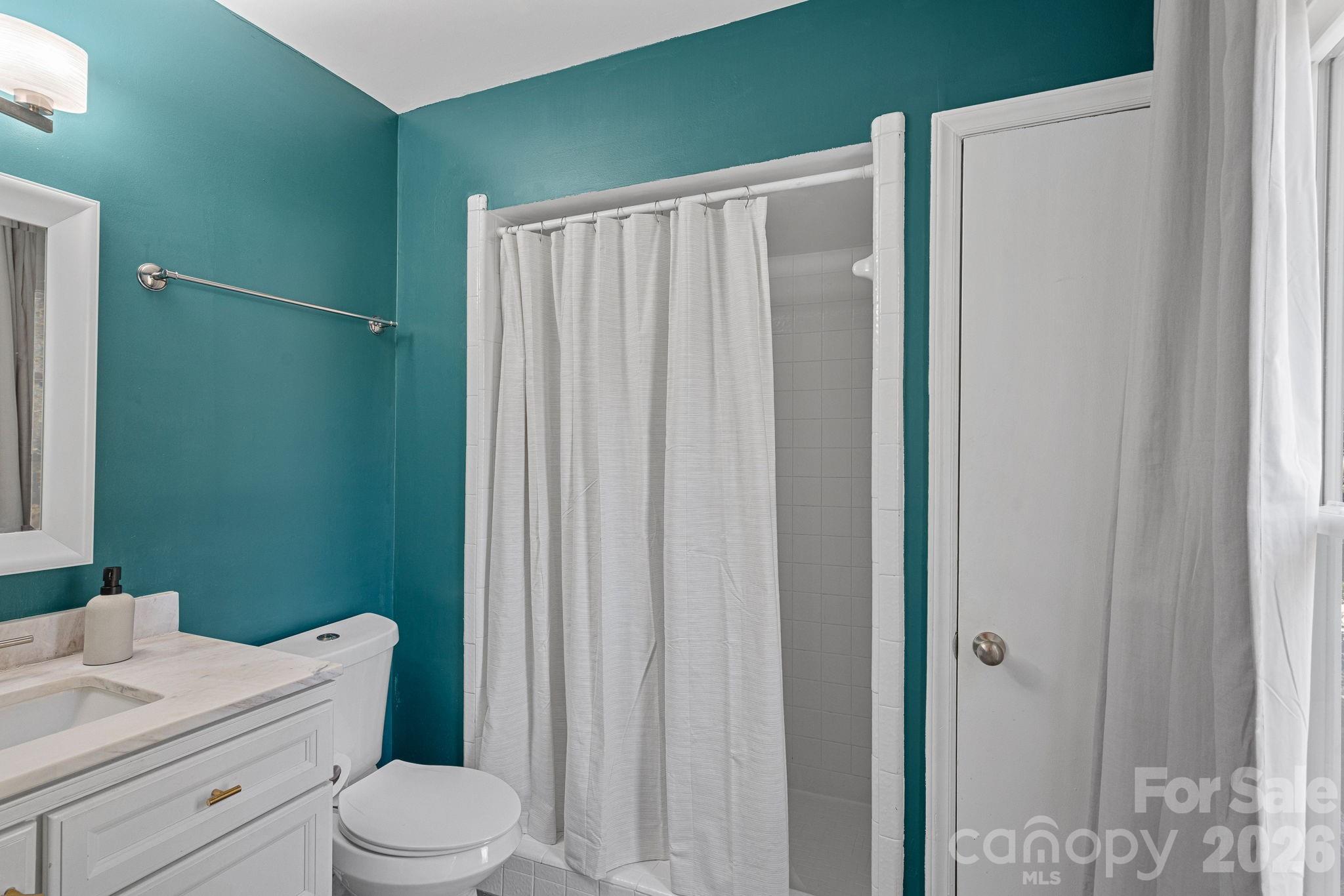 5236 Auburndale Road Charlotte, NC 28205 - Photo 14 of 26 a bathroom with a toilet a sink and shower