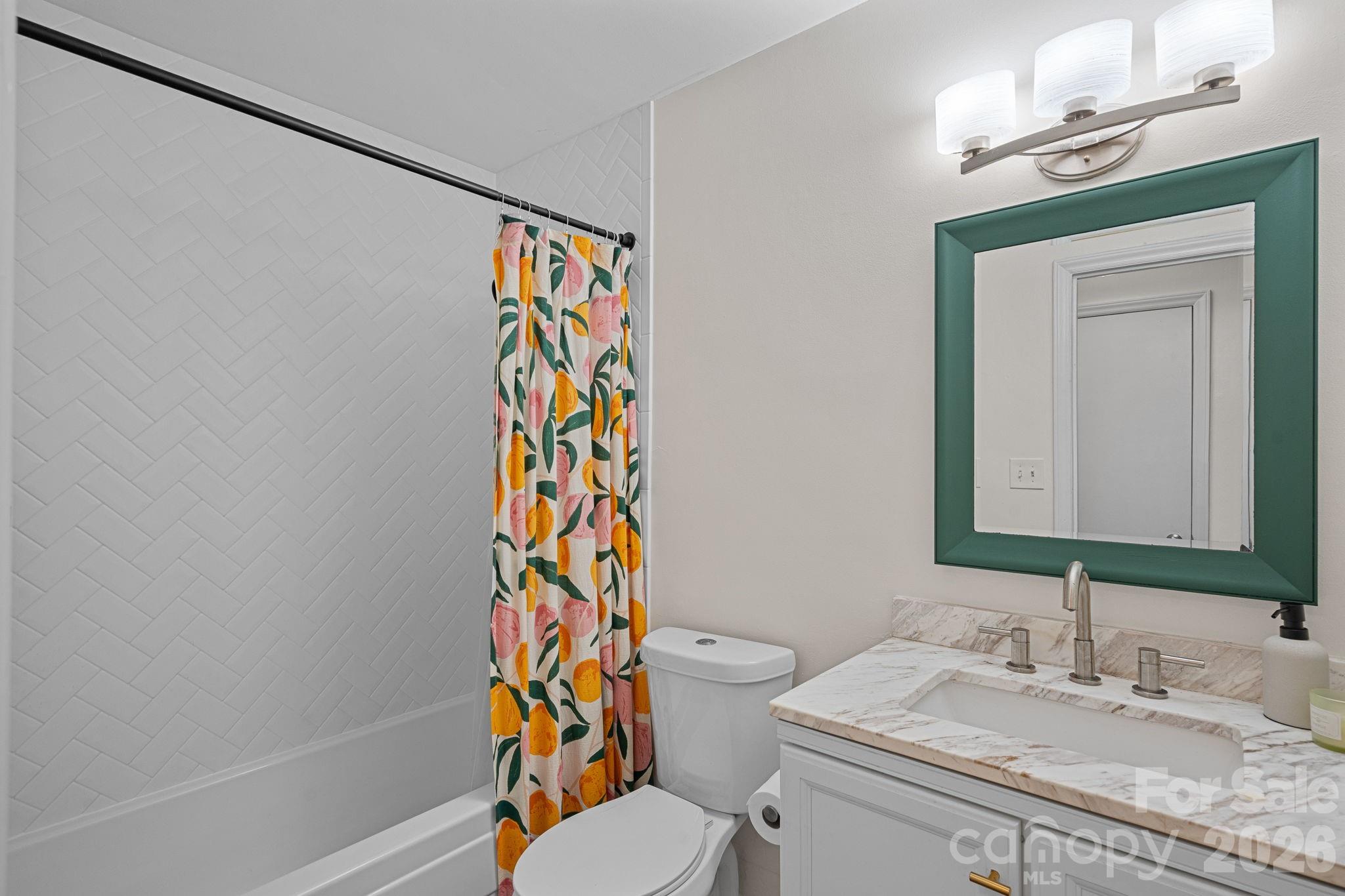 5236 Auburndale Road Charlotte, NC 28205 - Photo 19 of 26 a bathroom with a sink a toilet and shower curtain