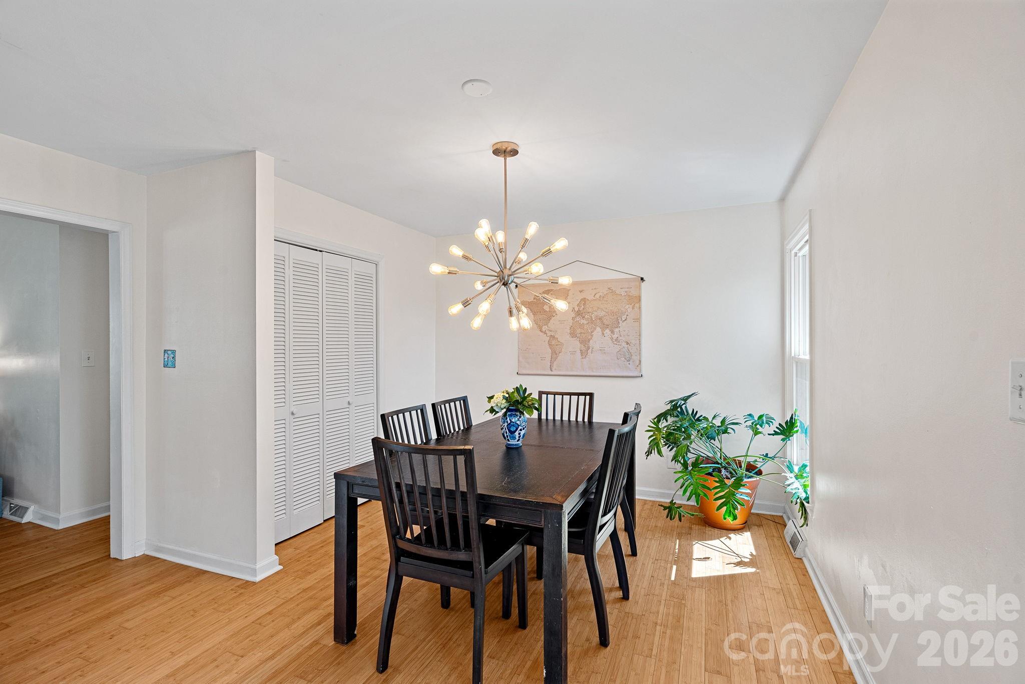 5236 Auburndale Road Charlotte, NC 28205 - Photo 9 of 26 a dining room with furniture a chandelier and wooden floor